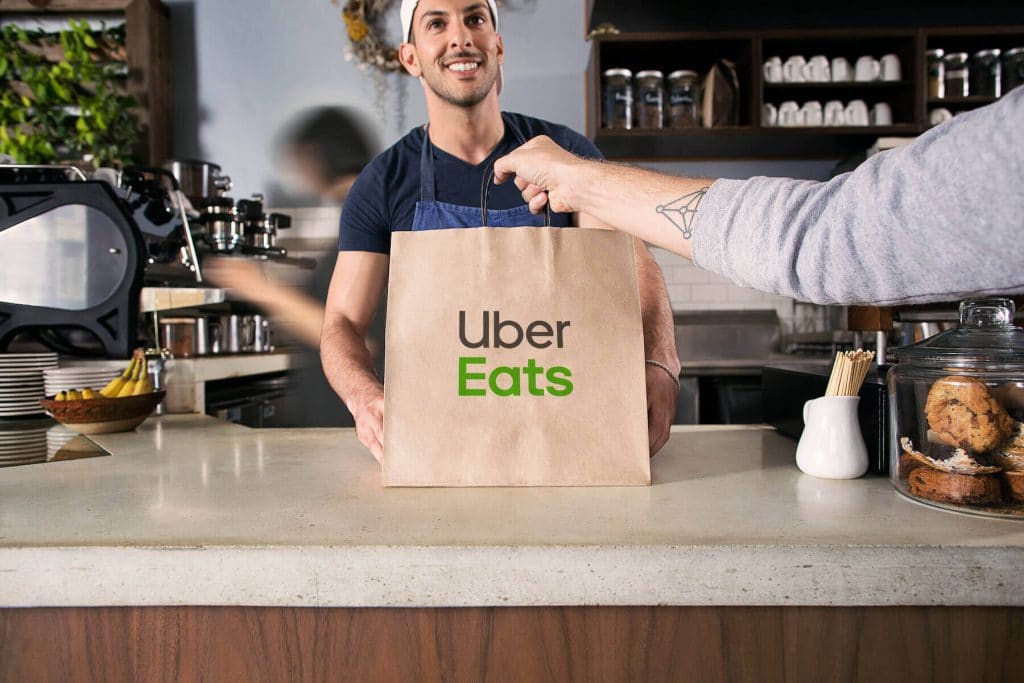 An Uber Eats driver picking up an order from a restaurant