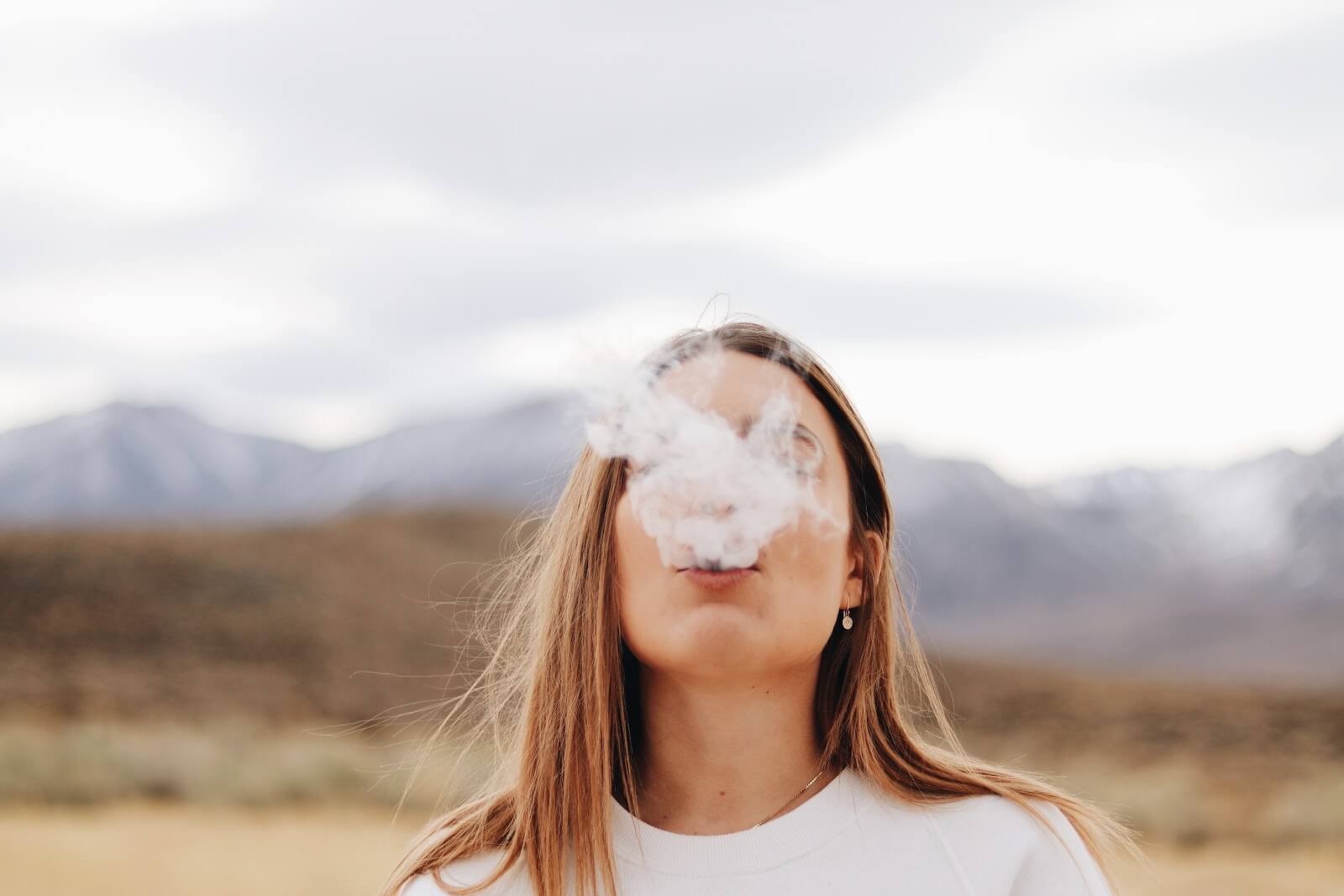 Eaze Promo Code: Woman blowing smoke out of her mouth