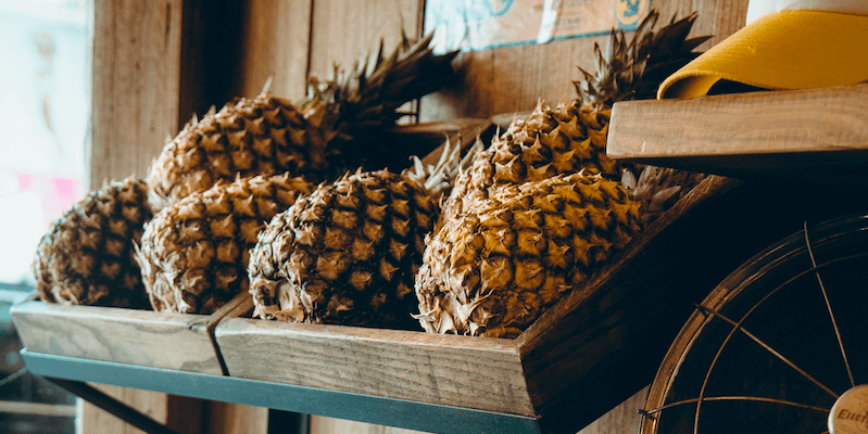 Instacart Locations: Six pineapples on a wooden crate
