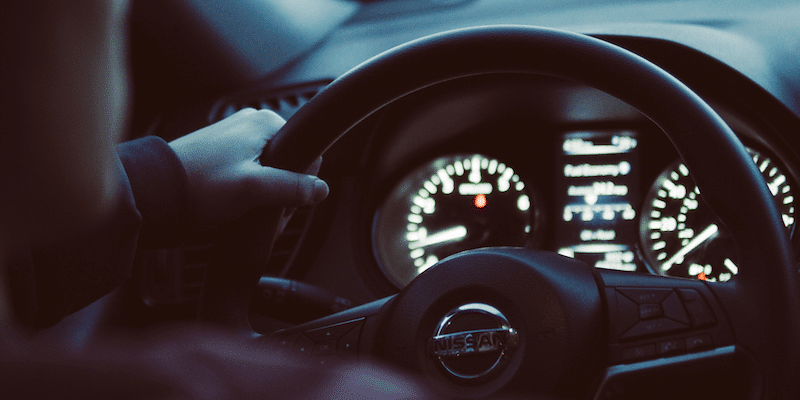 Person holds steering wheel driving for the gig economy