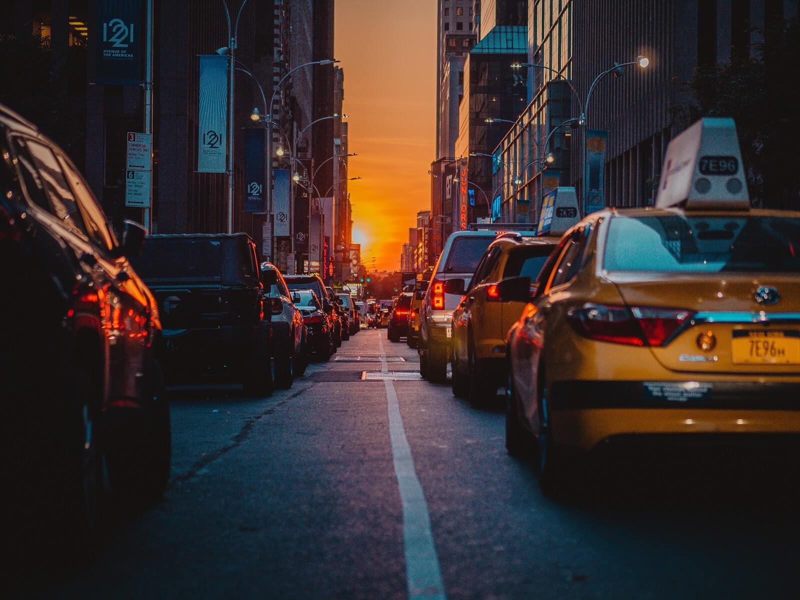 Uber vs Taxi: Line of taxis driving toward sunset