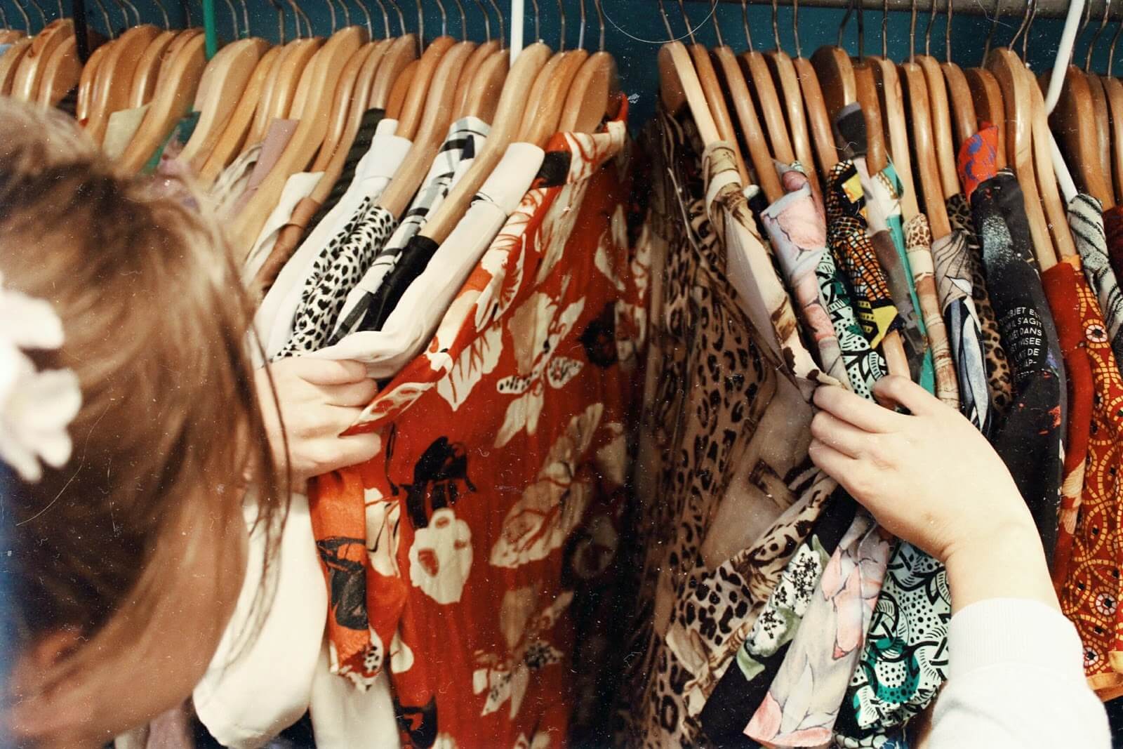 Woman searching through rack of clothing