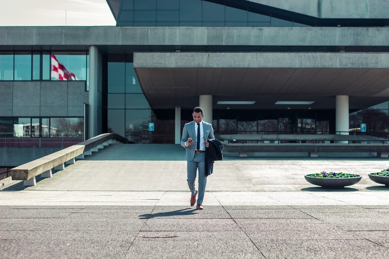 Uber for Business: A man in a business suit walks out of a building on his phone