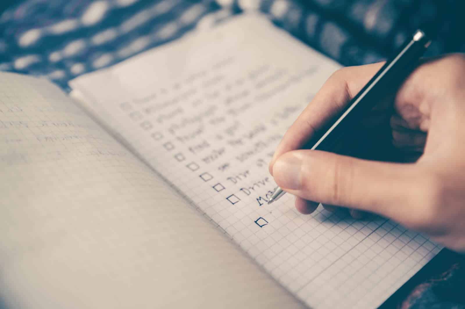 Checklist and person holding pen