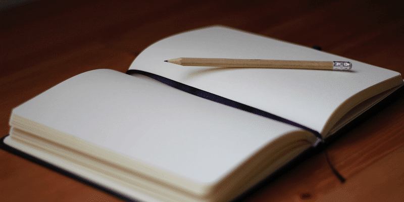 IRS mileage rate: Blank notebook and pencil