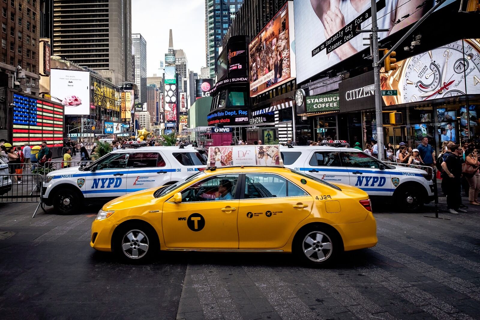 Taxi in New York in front of police cars
