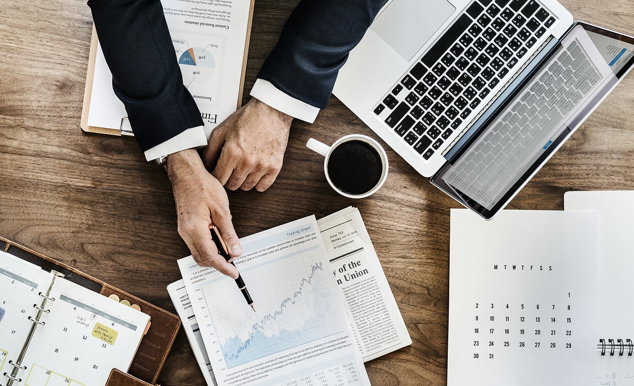 Residual income: overhead of a workspace, arms in a business suit point to charts and data