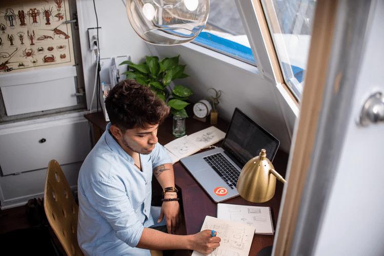 Jobs that pay well: A man writes at his home office desk