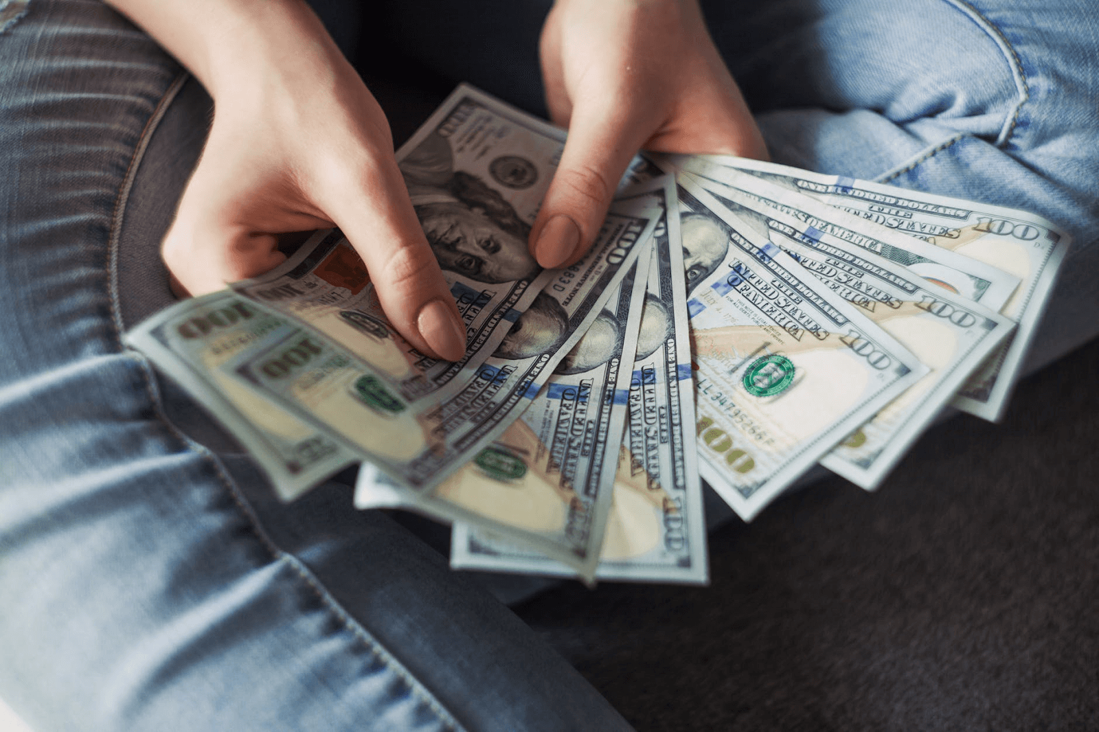 Loan amortization: A woman holds hundred dollar bills