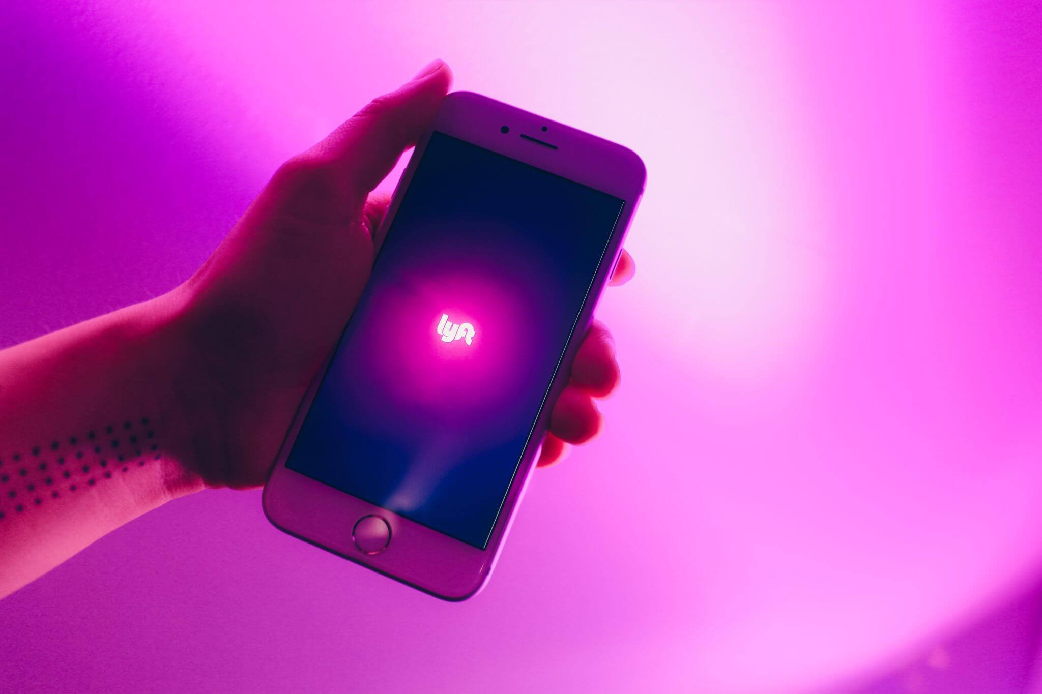 Lyft amp: A hand holds a phone screen open to the Lyft app