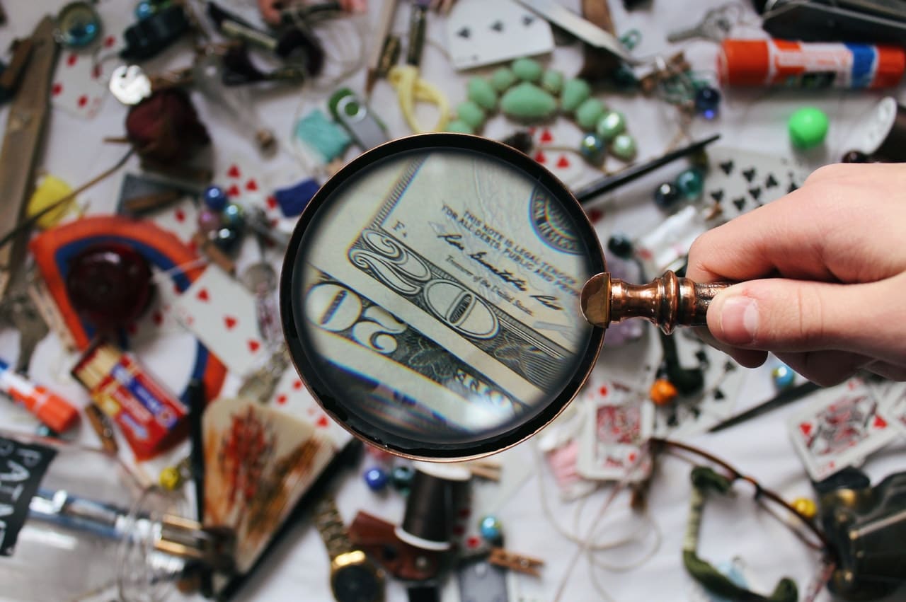 WeGoLook: a table of knick knacks with money spotted through a magnifying glass