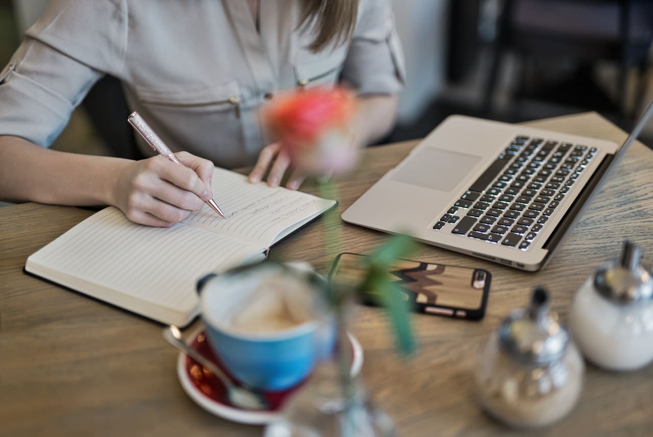 How to write an artist statement: A woman writes in a journal