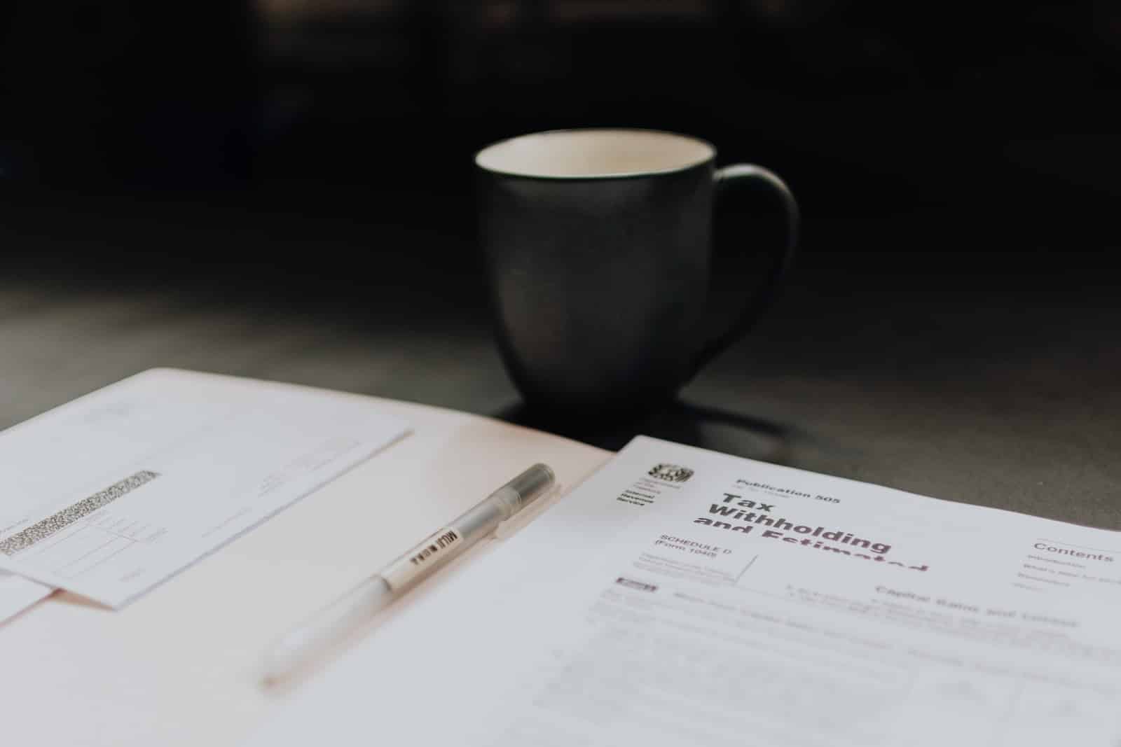How do you find a company's ein: A file folder with tax forms and a cup of coffee
