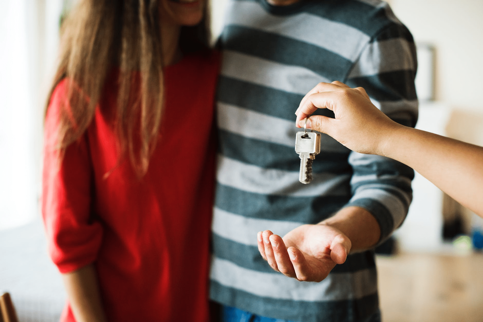 How to calculate net worth: A hand gives a couple the keys to a house