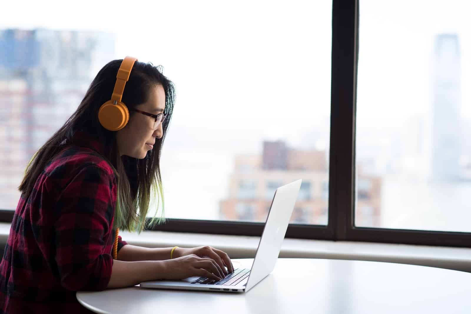 A Fancy Hands assistant wears head phones in front of her laptop