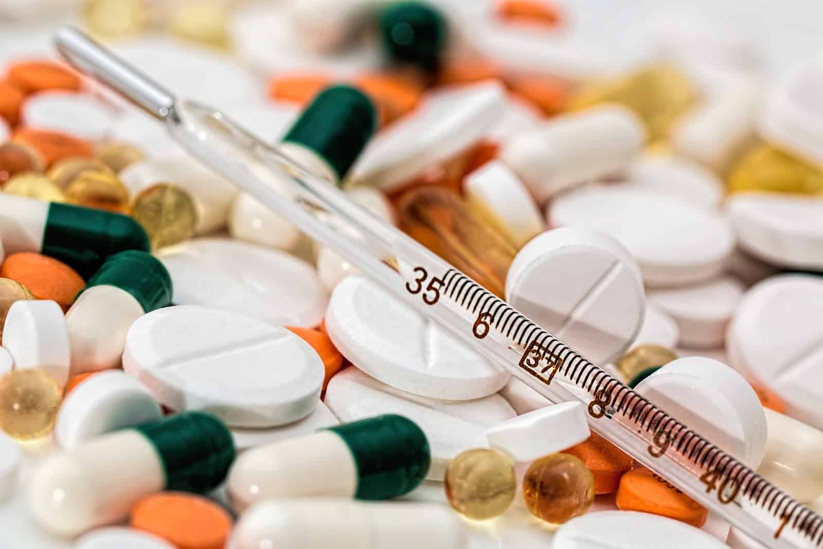 Work-from-home pharmacist jobs: a syringe on a pile of pills