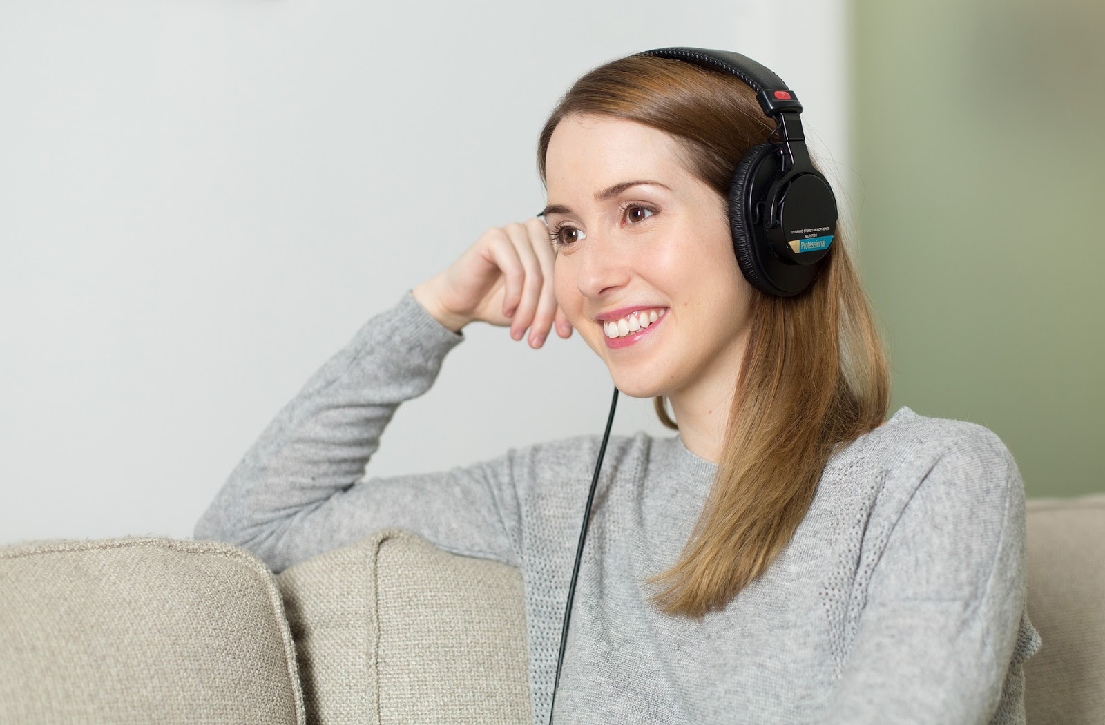 LanguageLine: A woman sits on her couch and listens to headphones