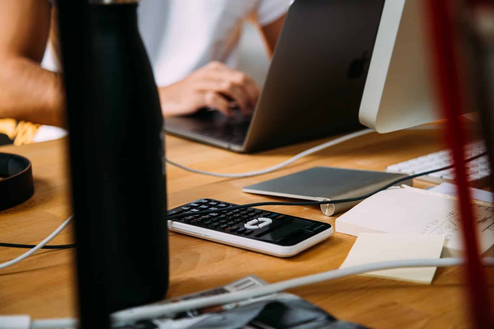 How to Calculate Depreciation: laptop and calculator on desk