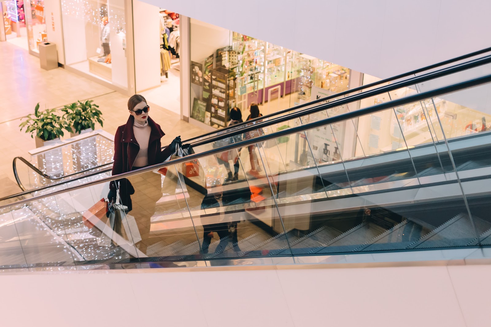 woman going up escalator