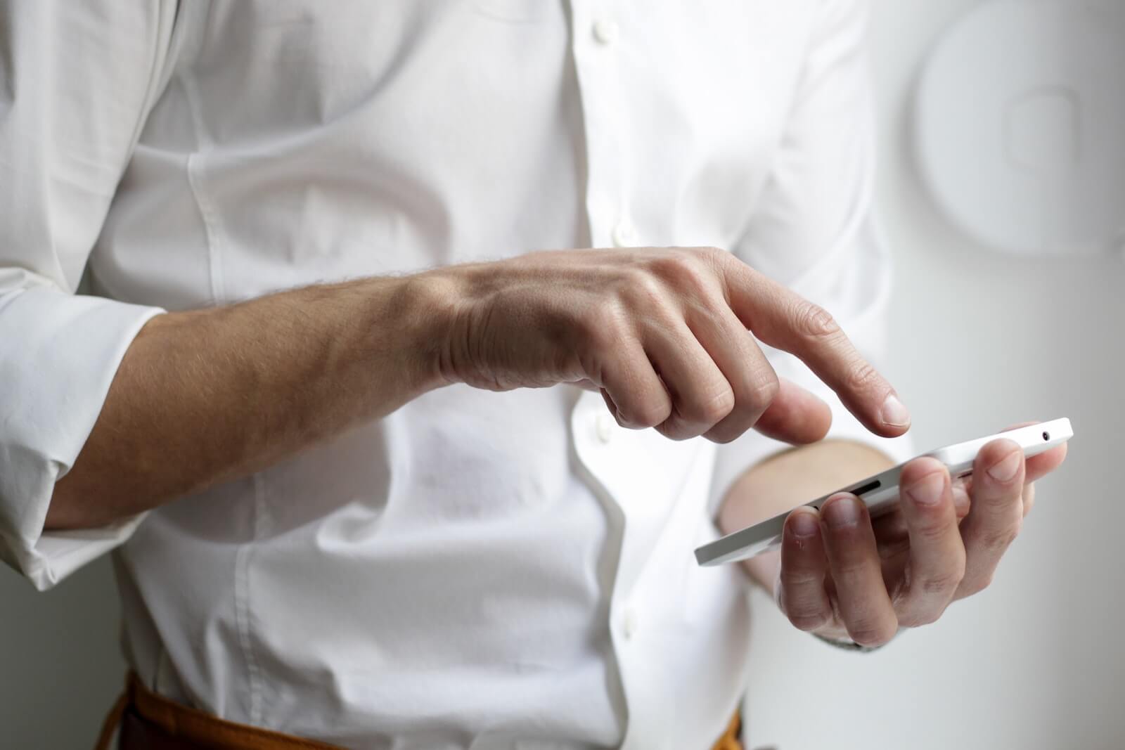 Field Agent: A man taps his smartphone screen