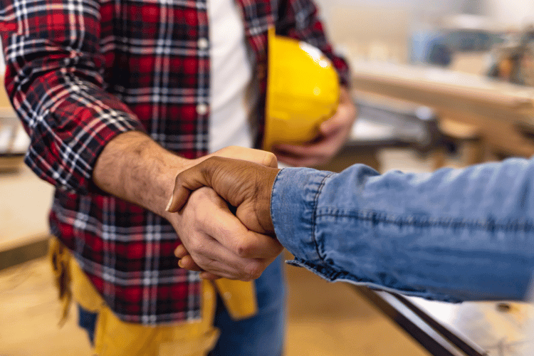 A close-up of home owner handshaking with a general contractor