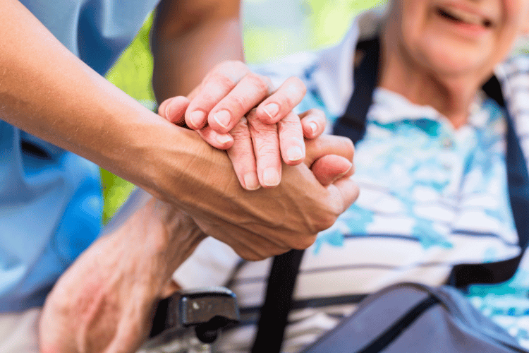 Close-up of a Caregiver holding an old woman's hands