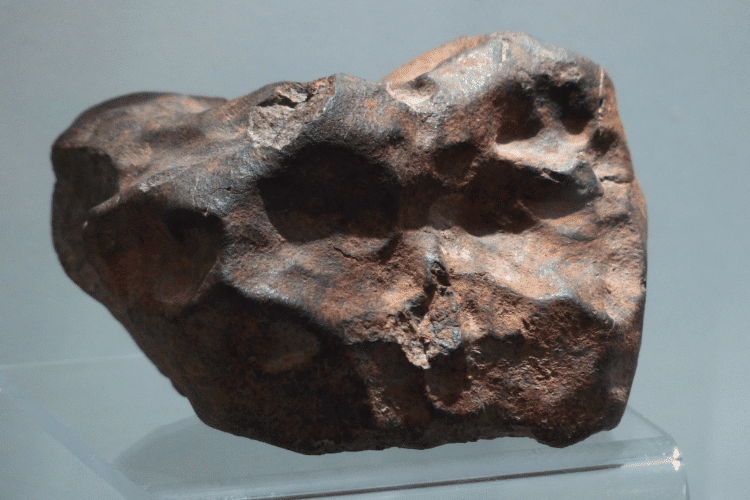 A Meteorite stone on a transparent plastic stand