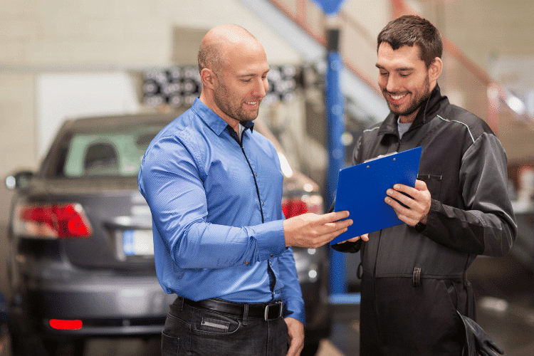 A car owner talking to a mechanic in a car service center