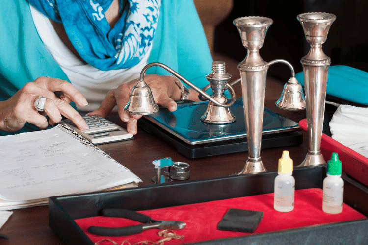 A close-up of a sliver buyer calculating the value of the weighted silver