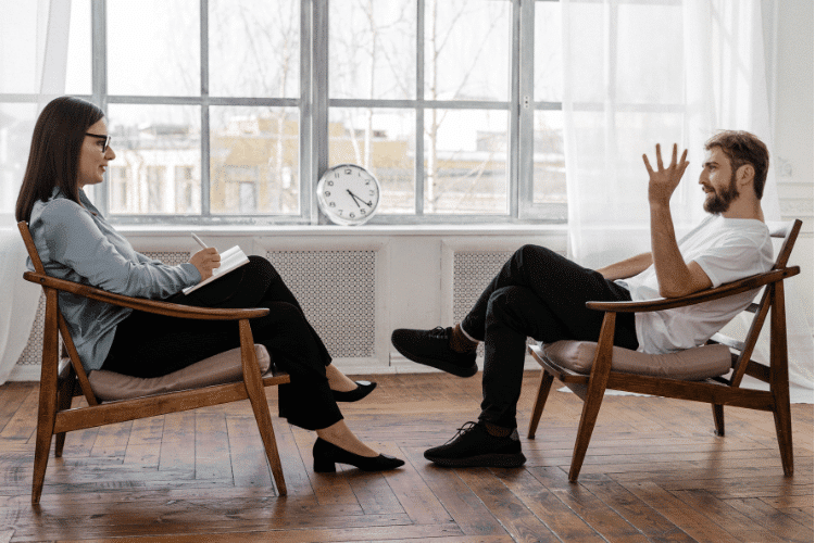 A female counselor Taking notes while talking to her client