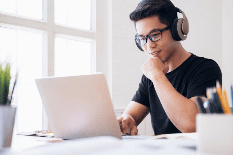 A young man studying online using his laptop