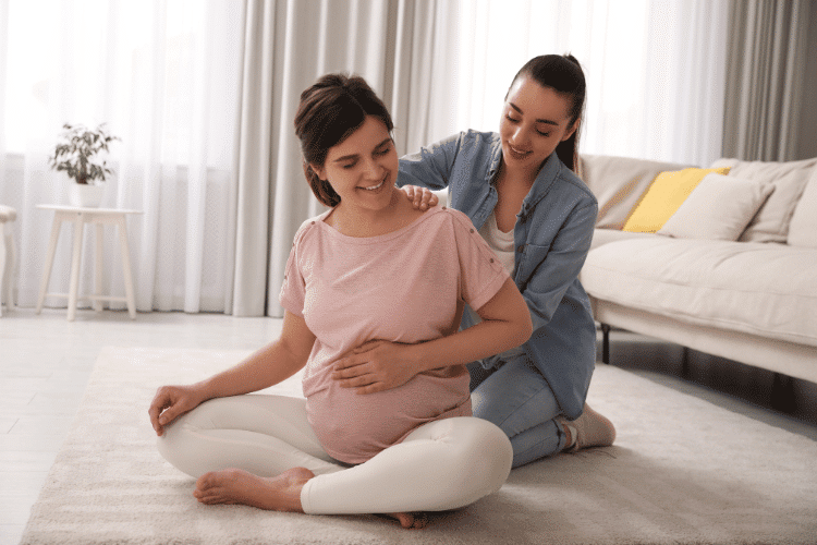A doula working with a pregnant woman in the living room